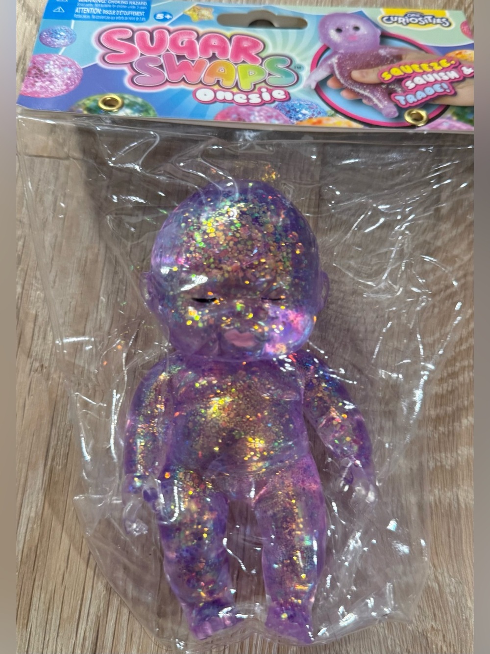 SUGAR SWAPS ONESIE PURPLE SQUISHY GLITTERY BABY FIGURE TOY. NEW IN UNOPENED PACK